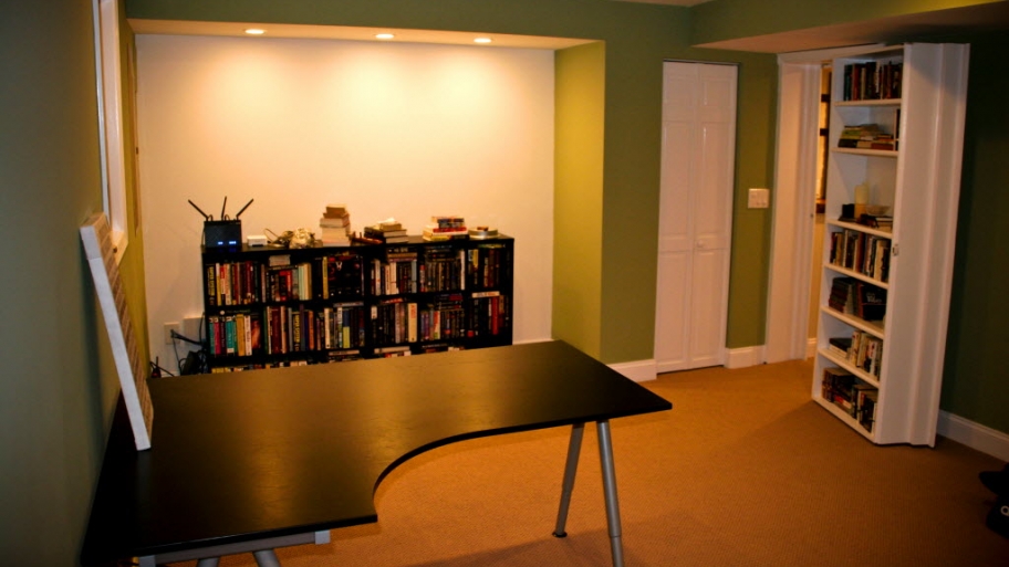 remodeled basement with built-in bookshelf that doubles as secret door to office